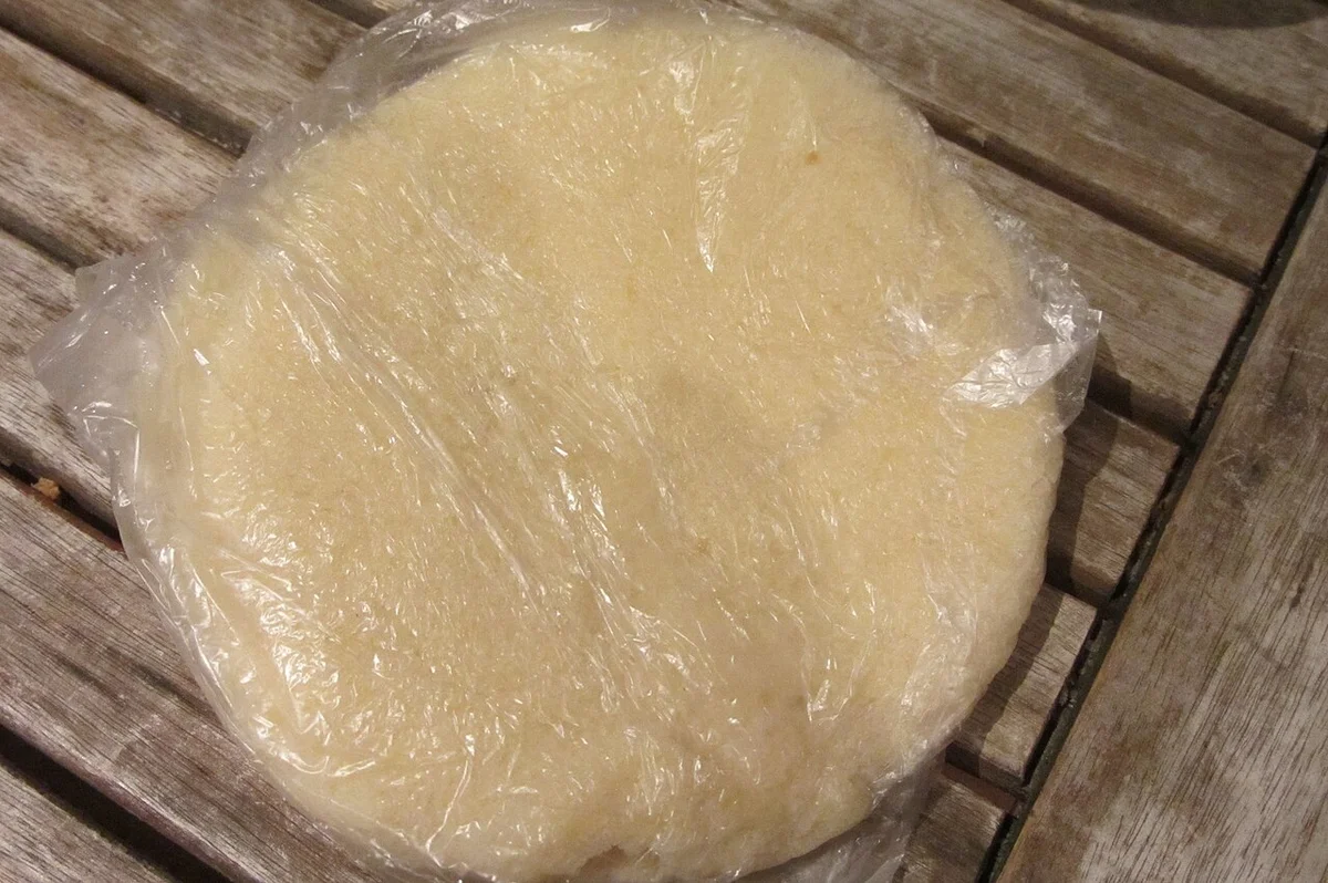 袋に入ったアチェケ（キャッサバクスクスの生地）。白っぽいクスクス状の粒が透明な袋に詰まっている