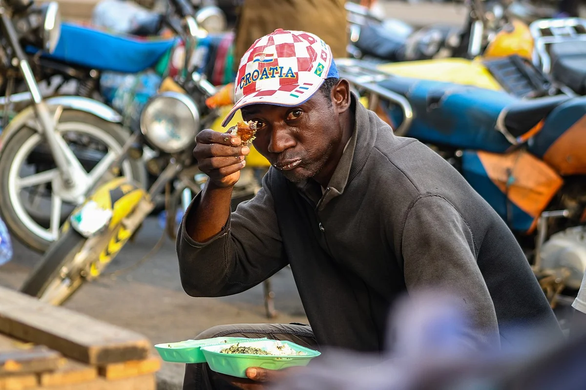 ドゥアラの路上でンドレを食べるカメルーン人男性