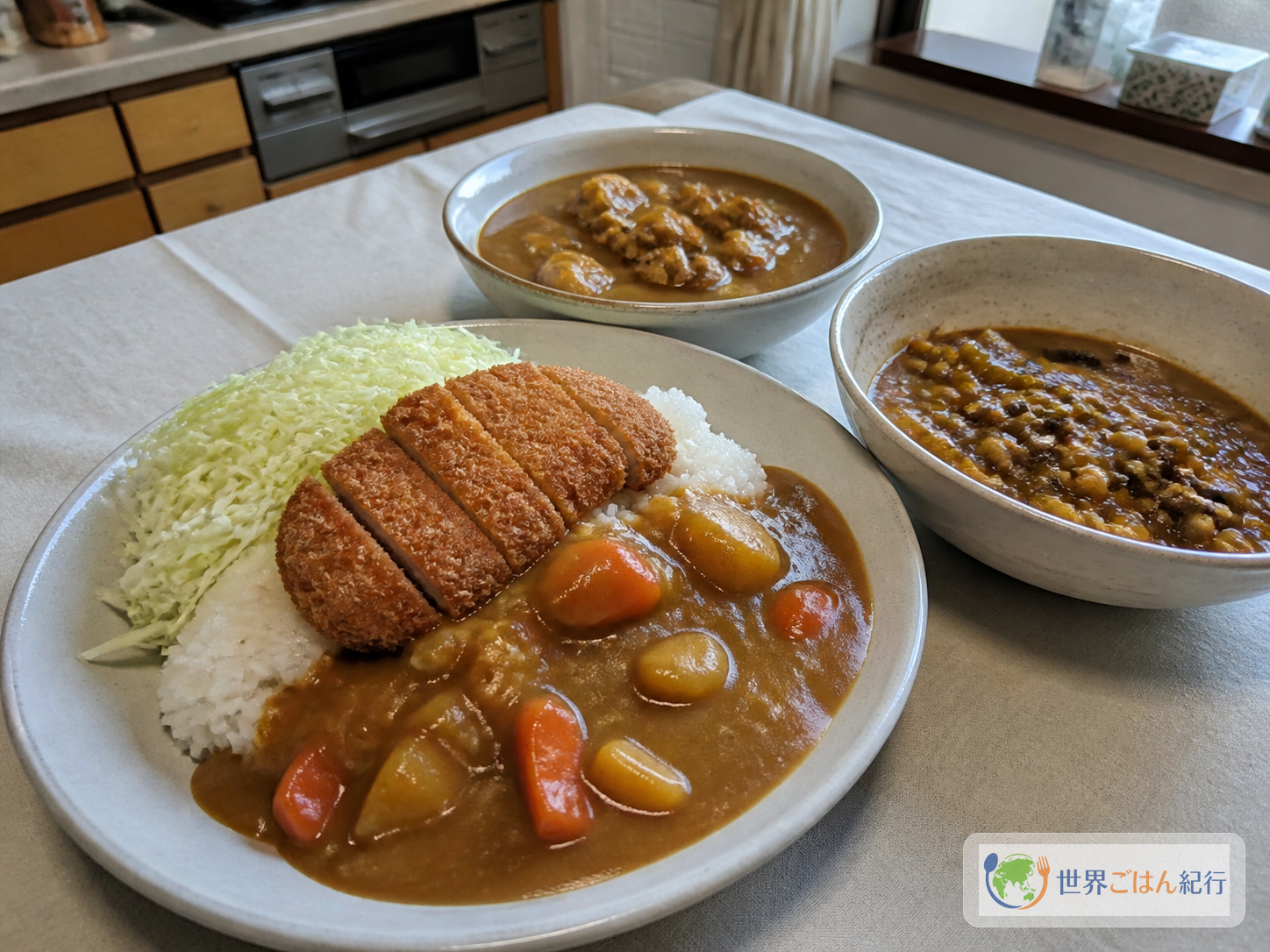 カレーライス、千切りキャベツを添えたカツカレー、野菜のスープカレーを並べた食卓