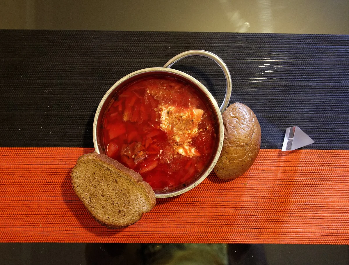 深紅のボルシチとサワークリーム、黒パンの組み合わせ