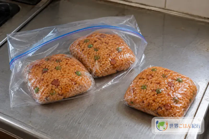 Leftover red rice wrapped in single portions in plastic wrap and put in a freezer bag