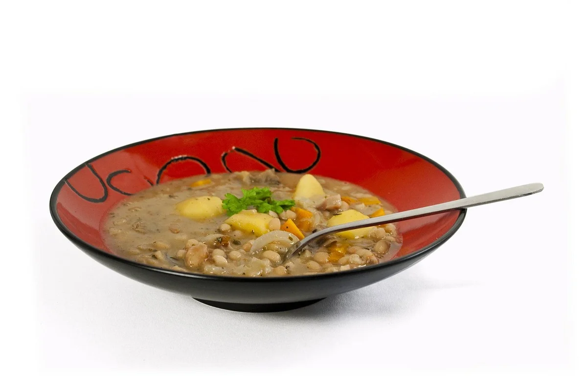 手順7: 肉を戻して仕上げ（10分）: オレンジとベイリーフを取り除く。肉が大きければ食べやすい大きさに切り分ける。蓋を外して中火で10分煮詰め、スープにとろみが出れば完成。塩・黒コショウで最終調味。スープをスプーンですくい、ゆっくり落ちるくらいの濃度が理想。