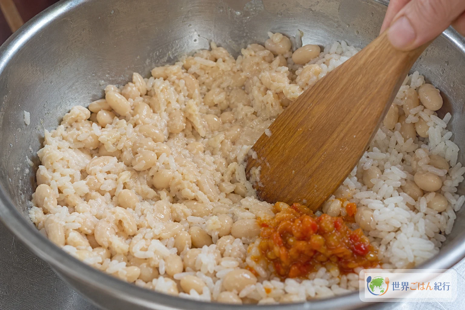 Étape où l'on presse à la spatule en bois la pâte de haricots et de riz du tacu tacu pour en faire une seule galette