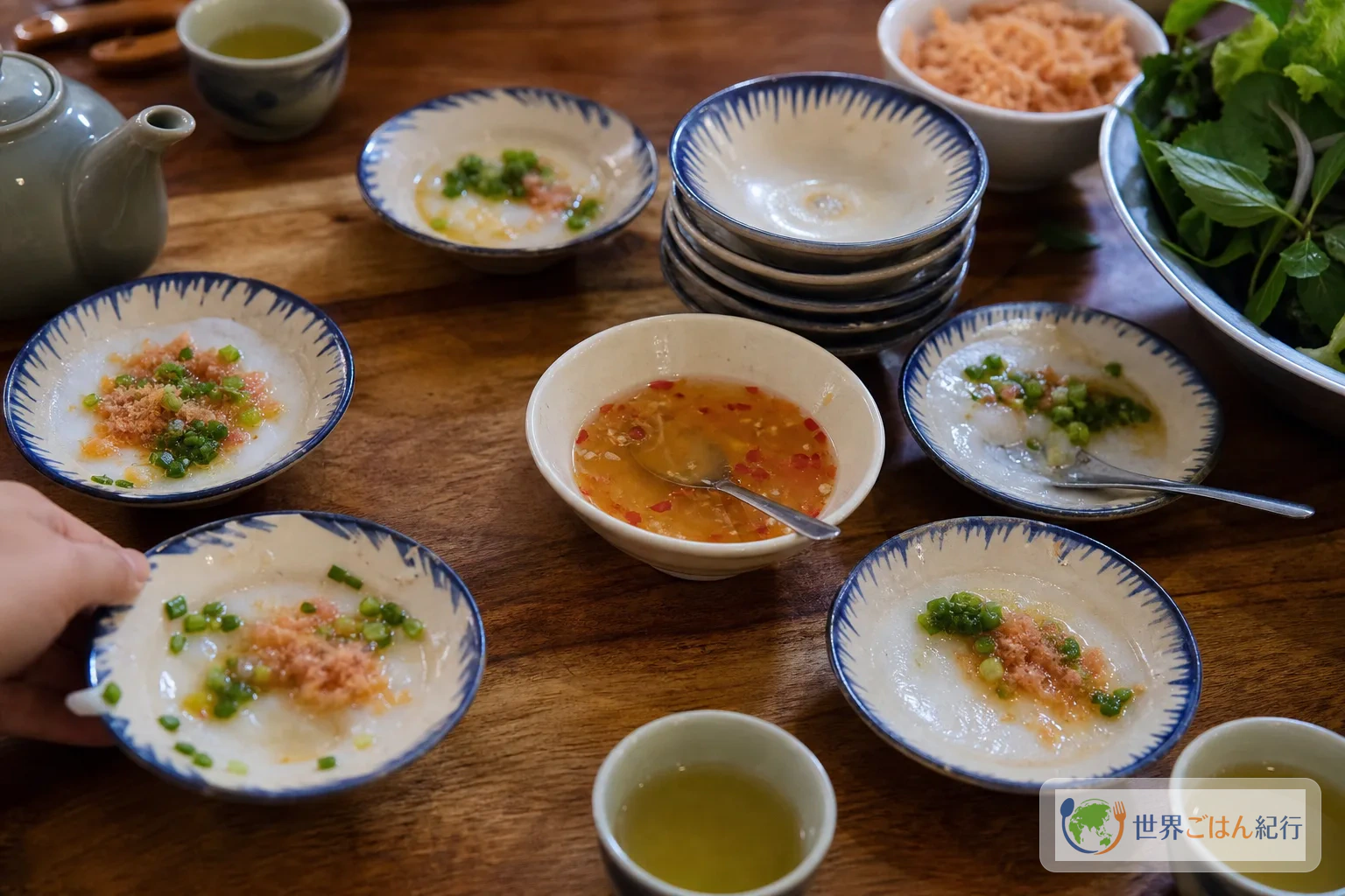 蒸したバインベオの小皿を、きゅうり、香草、ヌクチャムと一緒に並べた食卓